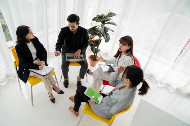 İş adamları daire içinde otururken iş projesini ustaca tartışıyor