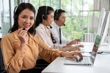 Kulaklık takan iş adamları ofiste aktif olarak çalışıyorlar.