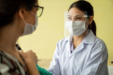 Genç bayan, aşı için yetenekli doktoru hastanede ziyaret ediyor.