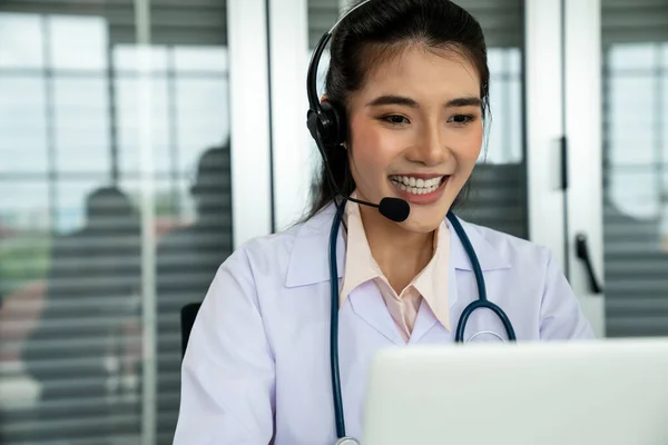 Medico indossando auricolare parlando attivamente in videochiamata in ospedale o in clinica — Foto Stock