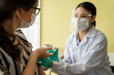 Genç bayan, aşı için yetenekli doktoru hastanede ziyaret ediyor.