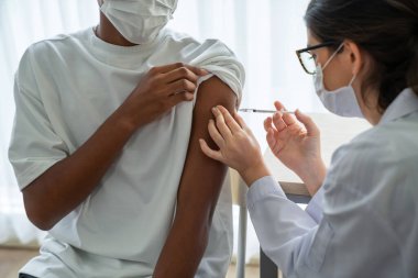 Genç adam, aşı için yetenekli doktoru hastanede ziyaret ediyor.