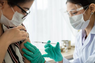 Genç bayan, aşı için yetenekli doktoru hastanede ziyaret ediyor.