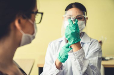 Genç bayan, aşı için yetenekli doktoru hastanede ziyaret ediyor.