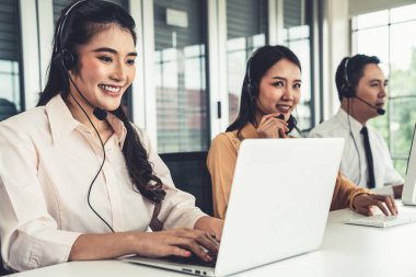 Kulaklık takan iş adamları ofiste aktif olarak çalışıyorlar.