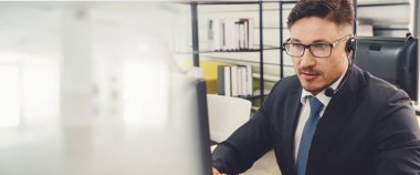 Ofiste çalışan, kulaklık takan iş adamları daha geniş görüşlü.