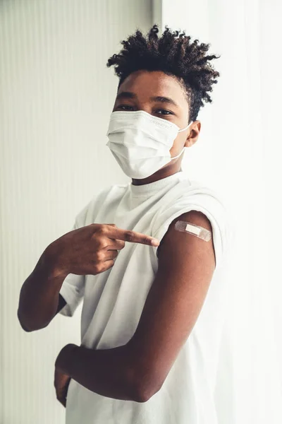 Adolescent afro-américain montrant joyeusement le bandage de vaccin COVID-19 — Photo