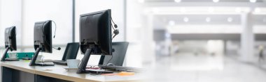 Call center computers and headsets all in office in widen view