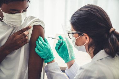 Genç adam, aşı için yetenekli doktoru hastanede ziyaret ediyor.