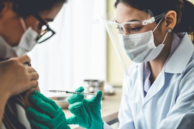 Genç bayan, aşı için yetenekli doktoru hastanede ziyaret ediyor.