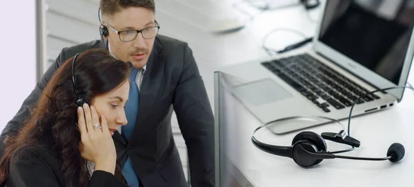 Zakenmensen die een headset dragen en op kantoor werken, verbreden het zicht — Stockfoto