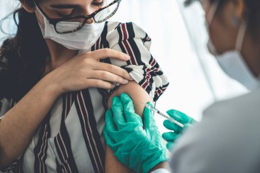 Genç bayan, aşı için yetenekli doktoru hastanede ziyaret ediyor.