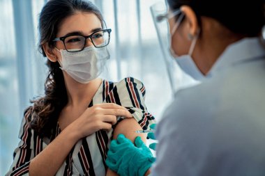 Genç bayan, aşı için yetenekli doktoru hastanede ziyaret ediyor.