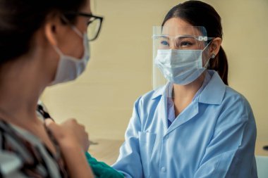 Genç bayan, aşı için yetenekli doktoru hastanede ziyaret ediyor.