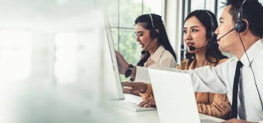 Kulaklık takan iş adamları ofiste aktif olarak çalışıyor.