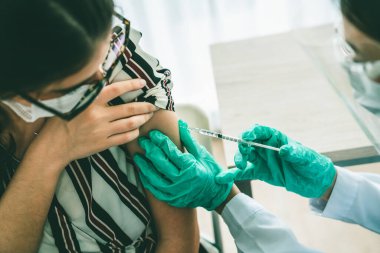 Genç bayan, aşı için yetenekli doktoru hastanede ziyaret ediyor.