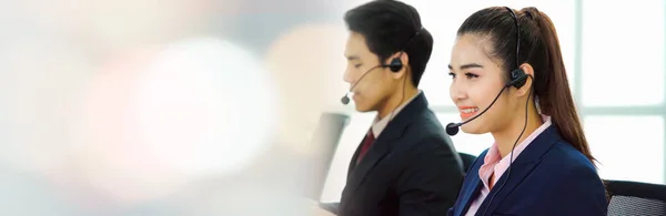 Business people wearing headset working in office in widen view