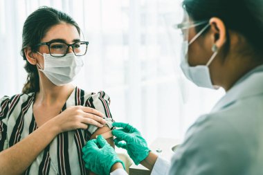 Genç bayan, aşı için yetenekli doktoru hastanede ziyaret ediyor.