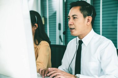 Kulaklık takan iş adamları ofiste aktif olarak çalışıyorlar.