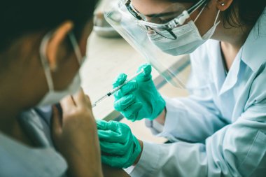 Genç bayan, aşı için yetenekli doktoru hastanede ziyaret ediyor.