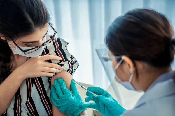 stock image Young woman visits skillful doctor at hospital for vaccination