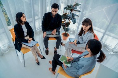 İş adamları daire içinde otururken iş projesini ustaca tartışıyor