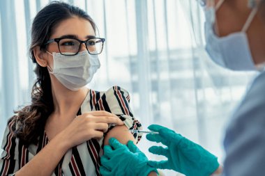 Genç bayan, aşı için yetenekli doktoru hastanede ziyaret ediyor.
