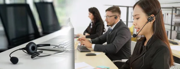 Business people wearing headset working in office broaden view