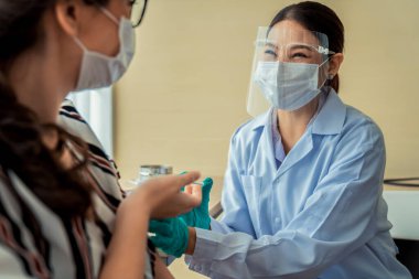 Genç bayan, aşı için yetenekli doktoru hastanede ziyaret ediyor.