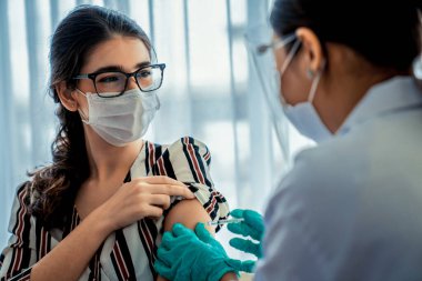 Genç bayan, aşı için yetenekli doktoru hastanede ziyaret ediyor.