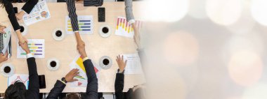 Toplantı masasında grup çalışanları el sıkışırken görünümü genişlet