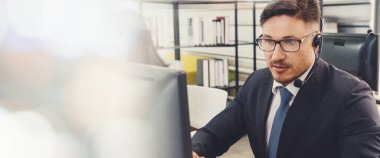 Ofiste çalışan, kulaklık takan iş adamları daha geniş görüşlü.