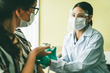 Genç bayan, aşı için yetenekli doktoru hastanede ziyaret ediyor.