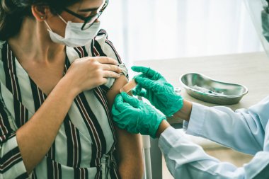 Genç bayan, aşı için yetenekli doktoru hastanede ziyaret ediyor.