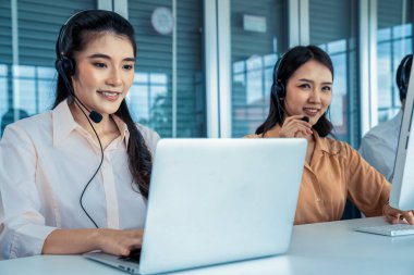 Kulaklık takan iş adamları ofiste aktif olarak çalışıyorlar.