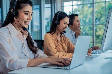 Kulaklık takan iş adamları ofiste aktif olarak çalışıyorlar.