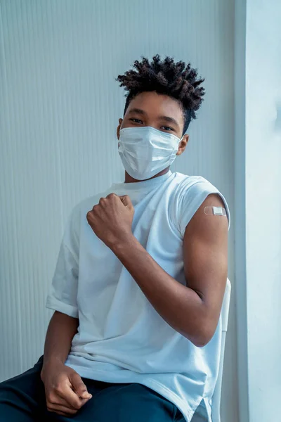 African American nastolatek pokazując COVID-19 szczepionka bandaż wesoło — Zdjęcie stockowe