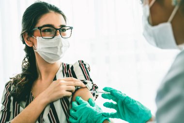 Genç bayan, aşı için yetenekli doktoru hastanede ziyaret ediyor.