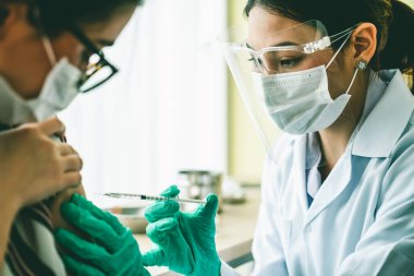 Genç bayan, aşı için yetenekli doktoru hastanede ziyaret ediyor.