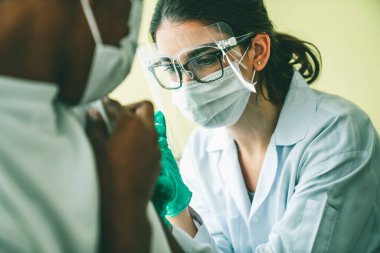 Genç adam, aşı için yetenekli doktoru hastanede ziyaret ediyor.