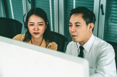 Kulaklık takan iş adamları ofiste aktif olarak çalışıyorlar.