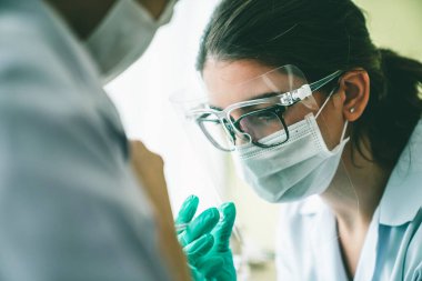 Genç bayan, aşı için yetenekli doktoru hastanede ziyaret ediyor.