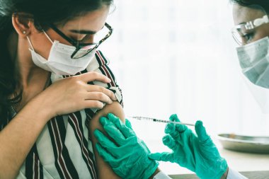 Genç bayan, aşı için yetenekli doktoru hastanede ziyaret ediyor.