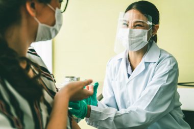 Genç bayan, aşı için yetenekli doktoru hastanede ziyaret ediyor.