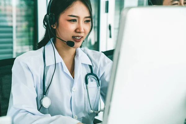 Medico indossando auricolare parlando attivamente in videochiamata in ospedale o in clinica — Foto Stock