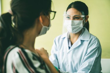 Genç bayan, aşı için yetenekli doktoru hastanede ziyaret ediyor.
