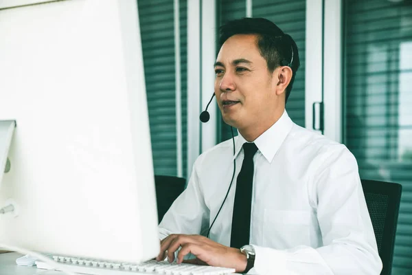 Geschäftsmann mit Headset arbeitet aktiv im Büro — Stockfoto