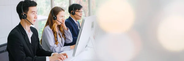 Business people wearing headset working in office in broaden view — стоковое фото