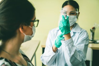 Genç bayan, aşı için yetenekli doktoru hastanede ziyaret ediyor.