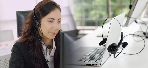 Vezetékes fülhallgatót viselő üzletemberek, akik irodai tágabb nézetben dolgoznak — Stock Fotó